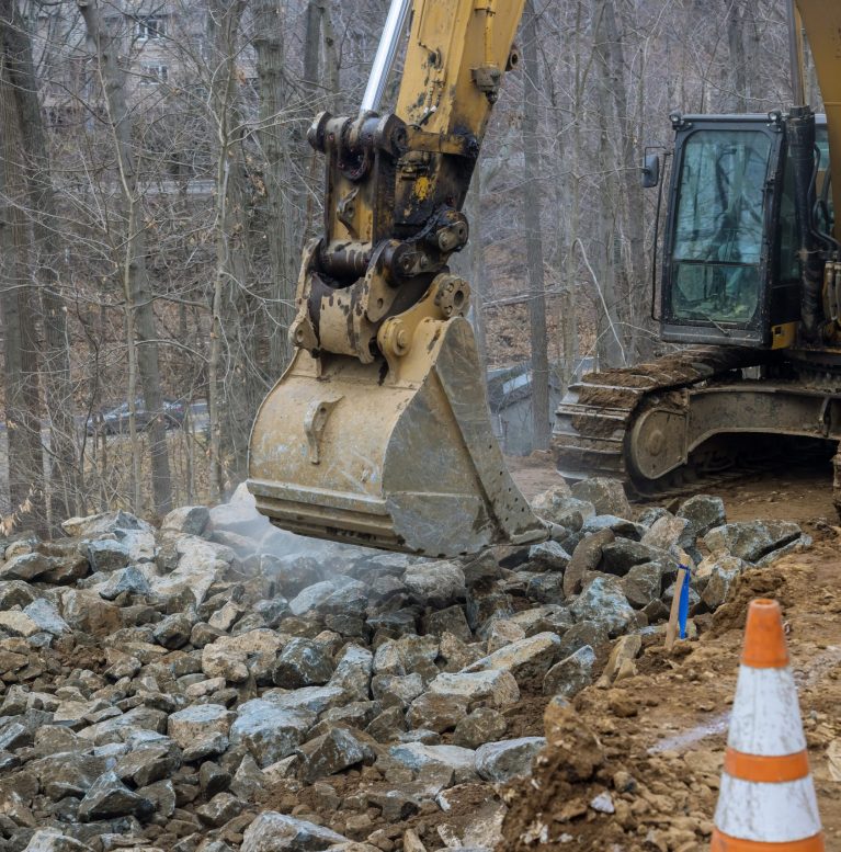 Heavy trucks with moving stone rock in a construction site on excavator load gravel